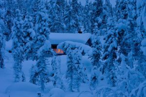 Wilderness cabin in the snow covered forest. Inside warm and cosy.