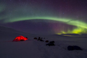 Northern lights, Aurora Borealis over tent camp on the tour: Sled dog adventure through Sjaunja and Kebnekaise