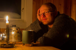 Reflektioner i ljuset av ett stearinljus i en fjällstuga. På äventyr med hundspann genom Lappland.
