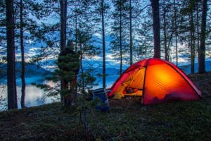 Lit Hilleberg tent in summer Swedish Lapland. Canoeing in the Pearl river Nature Reserve with Jokkmokkguiderna.
