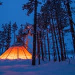 Lit tipi tent in Jokkmokk winter time. Photo from the Northern lights tour with dog sled.